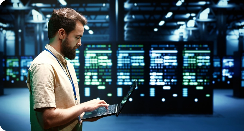 An individual working on a laptop inside a data center facility