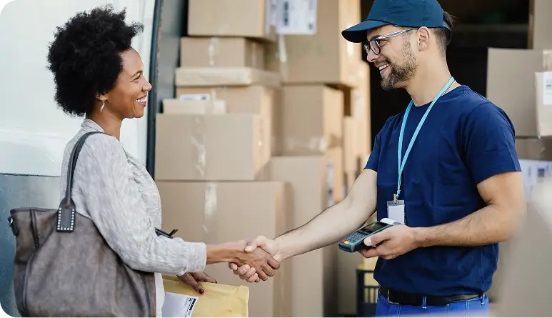 A delivery worker handing over a package and shaking hands with a customer